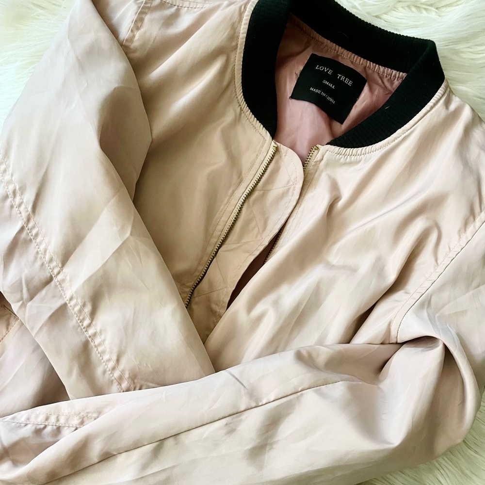 light pink jacket w/ black detailing + gold zippers!